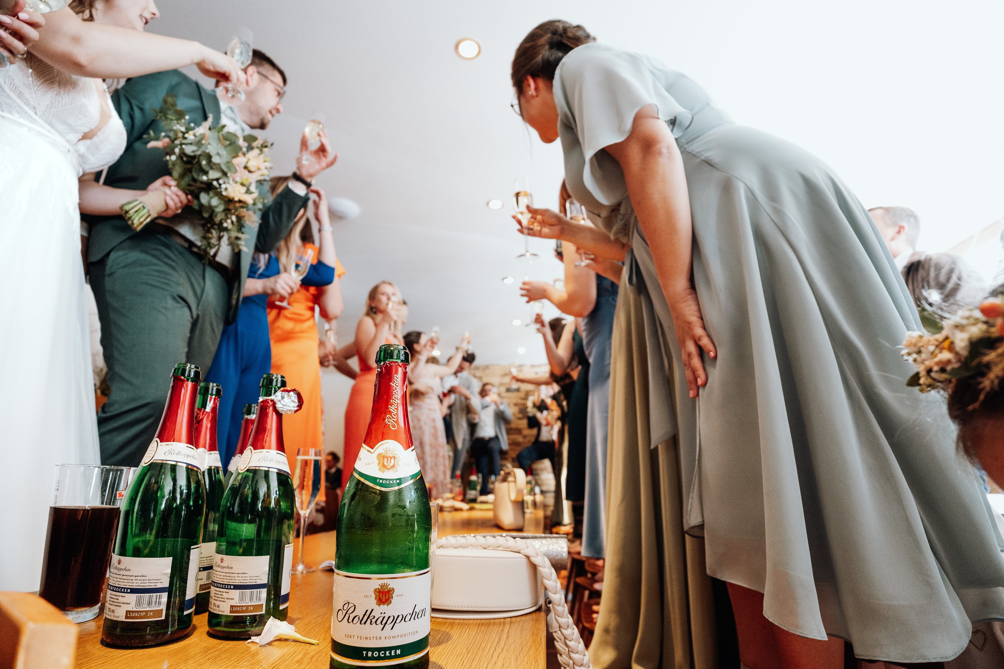 Foto von der Hochzeitsfeier in einer Kneipe im Fokus stehen Rotkäppchen-Sektflaschen