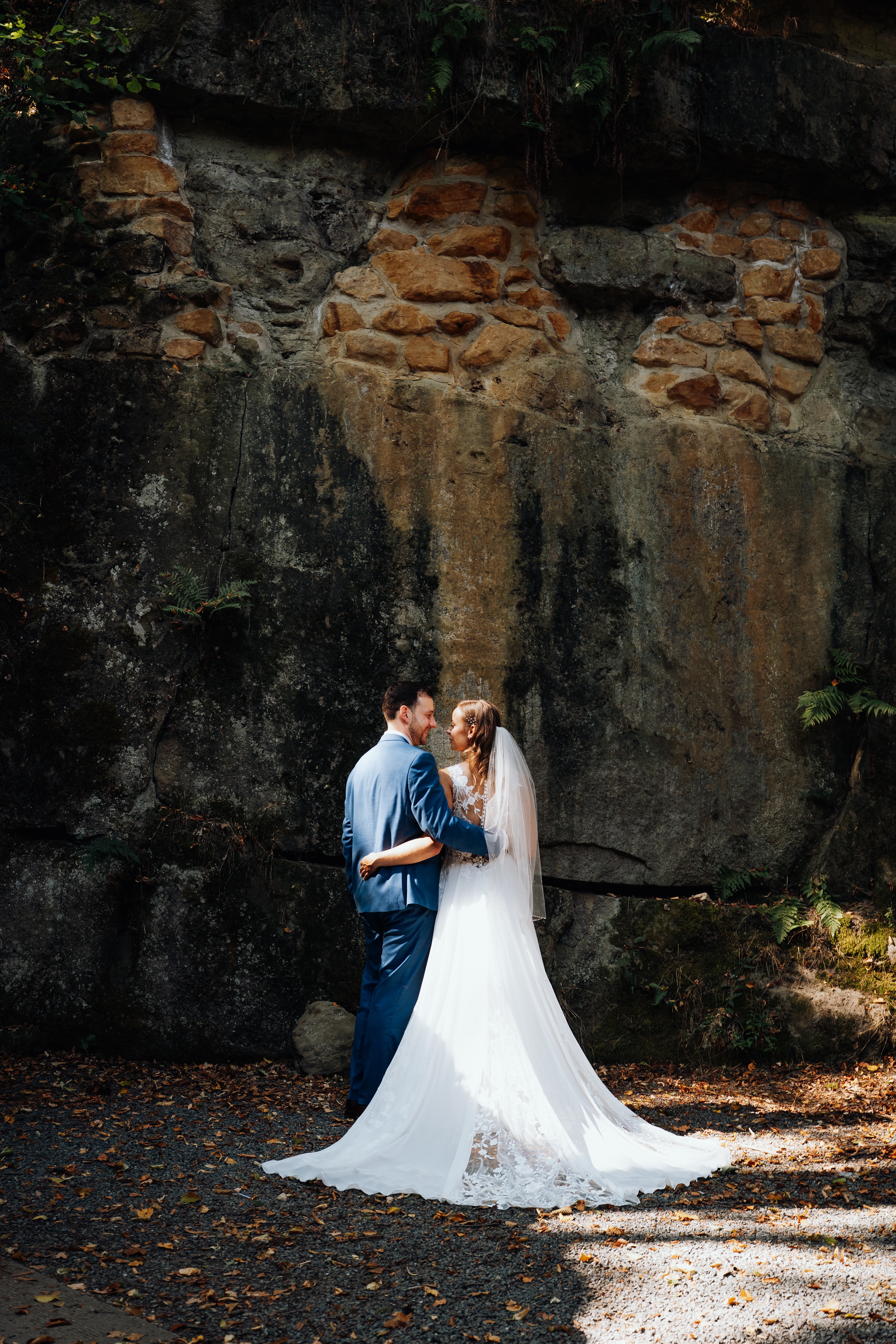 Foto vpn ein Brautpaar vor einem Fels umarmen sich und lächeln