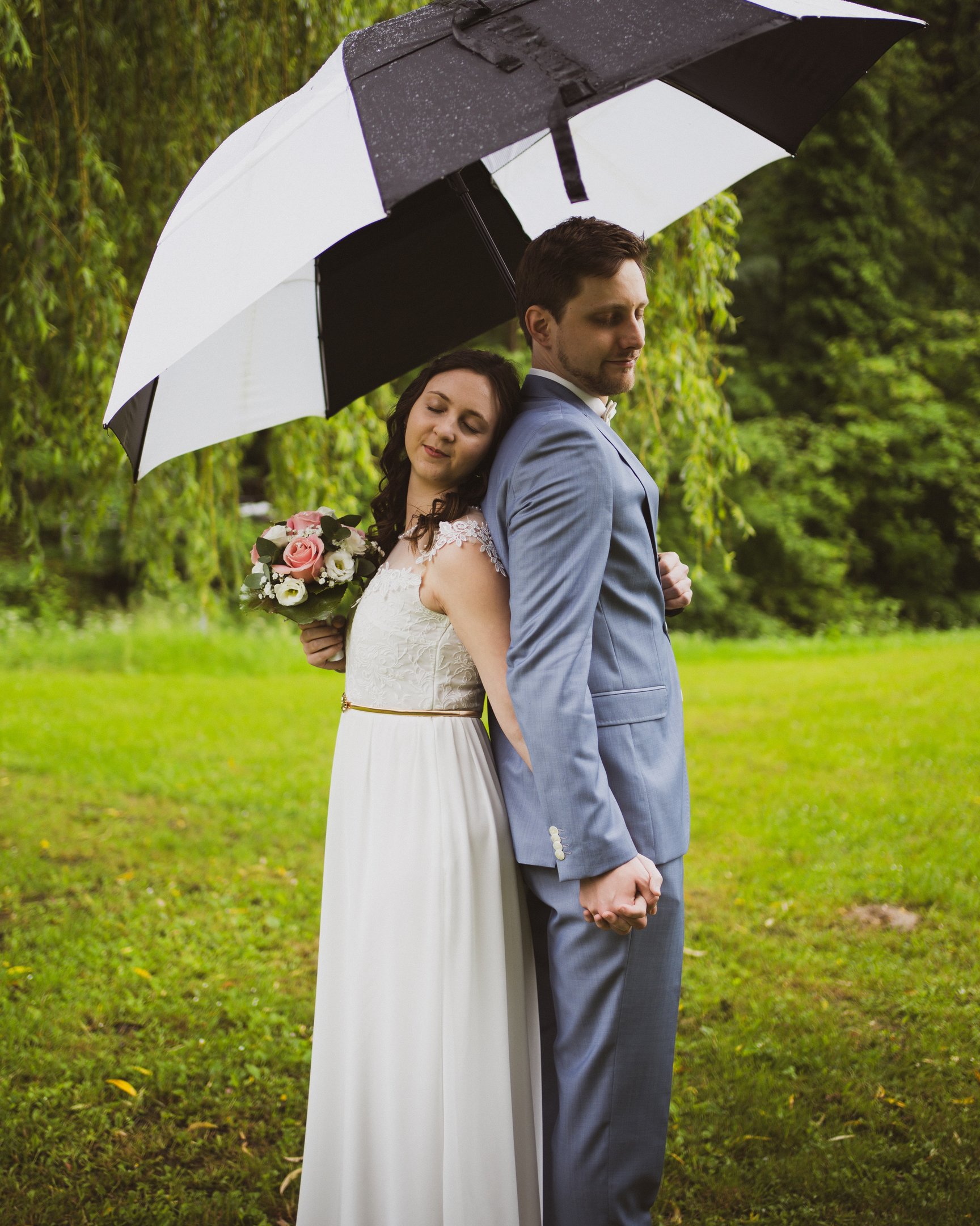 Hochzeitsfoto eines Paares beim Firstlook Rücken an Rücken stehend von umkaweddings