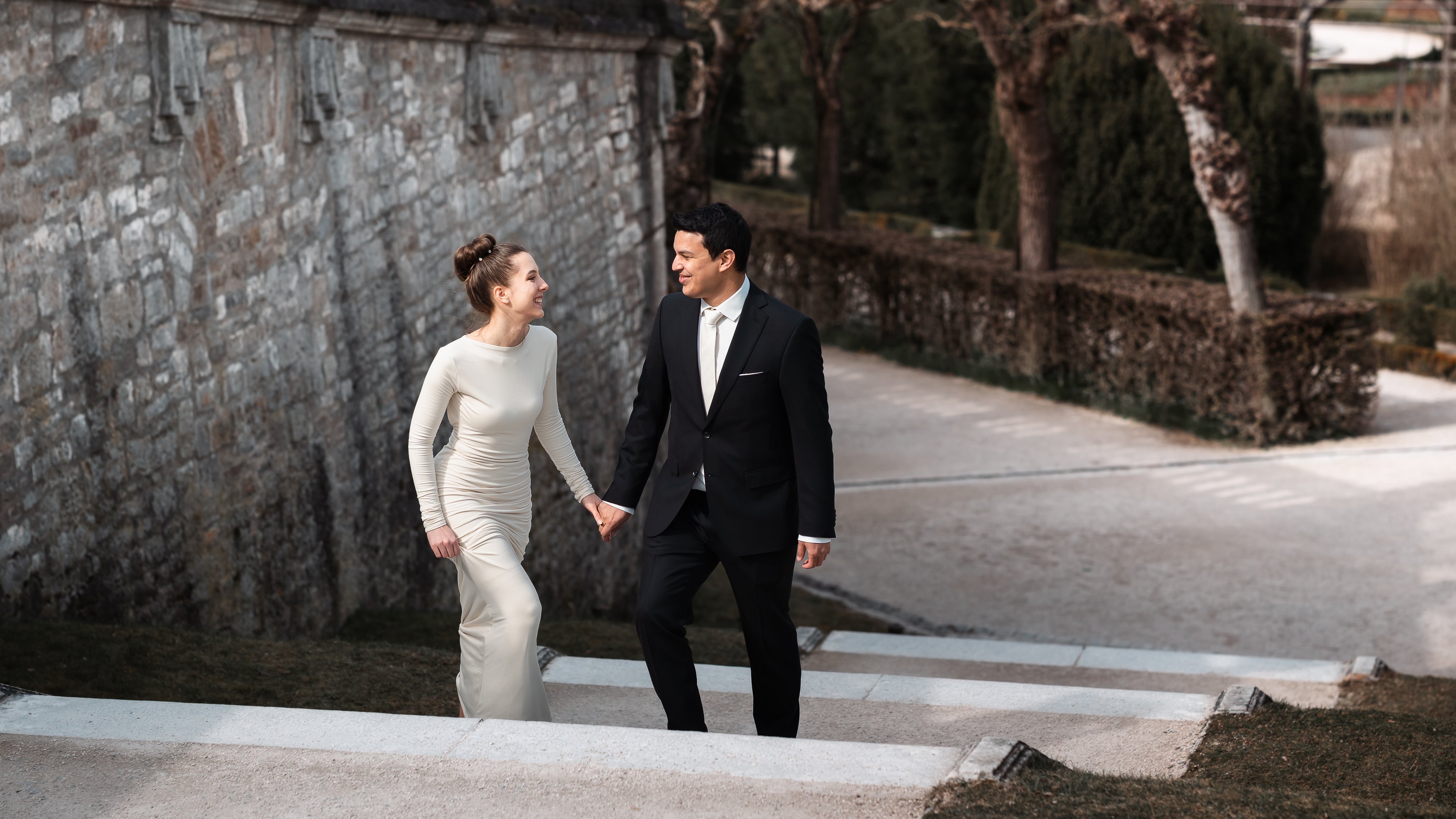 Hochzeitsfoto vom Hochzeitspaar, haltet sich an den Händen und läuft eine Treppe hoch