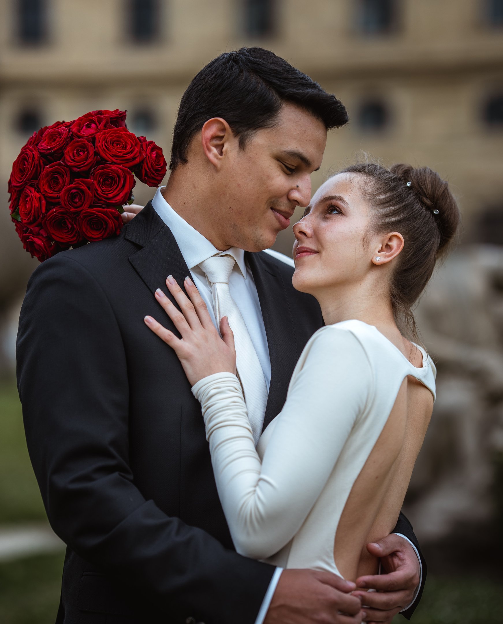 Hochzeitsfoto vom Hochzeitspaar mit rotem Brautstrauß aus roten Rosen