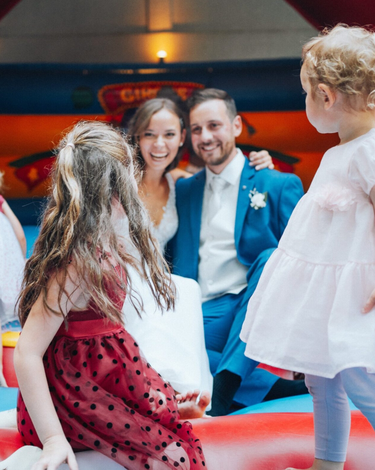Hochzeitsfoto von einem Paar mit Kindern auf einer Hüpfburg